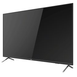 Ein moderner Flachbildfernseher in schwarzem Gehäuse, schräg von links betrachtet, auf zwei Metallfüßen stehend.